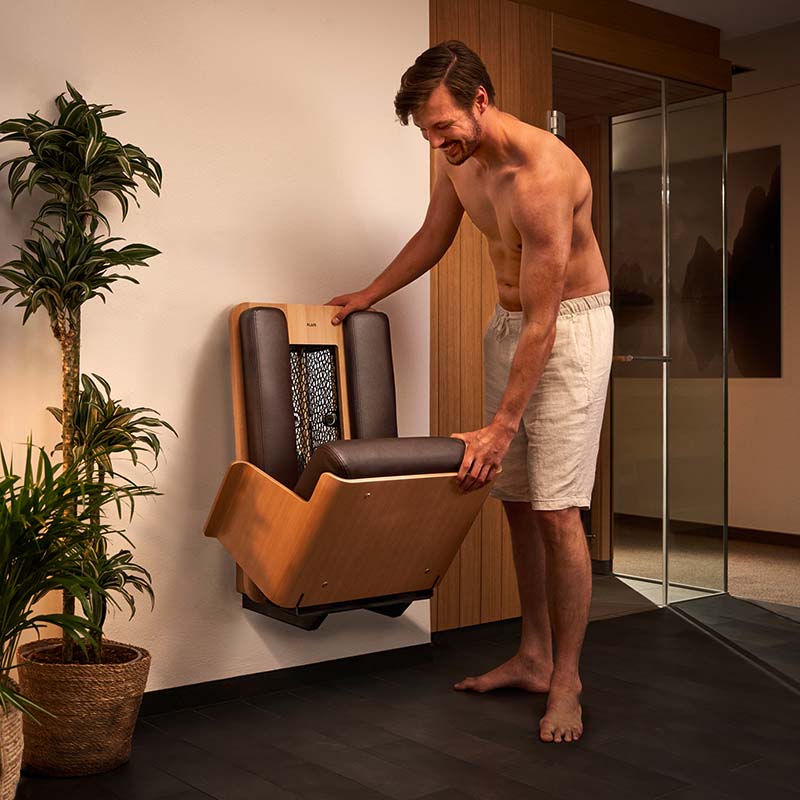 Klappfunktion des InfraPLUS SMART SEAT braun Mann klappt InfraPLUS SMART SEAT auf